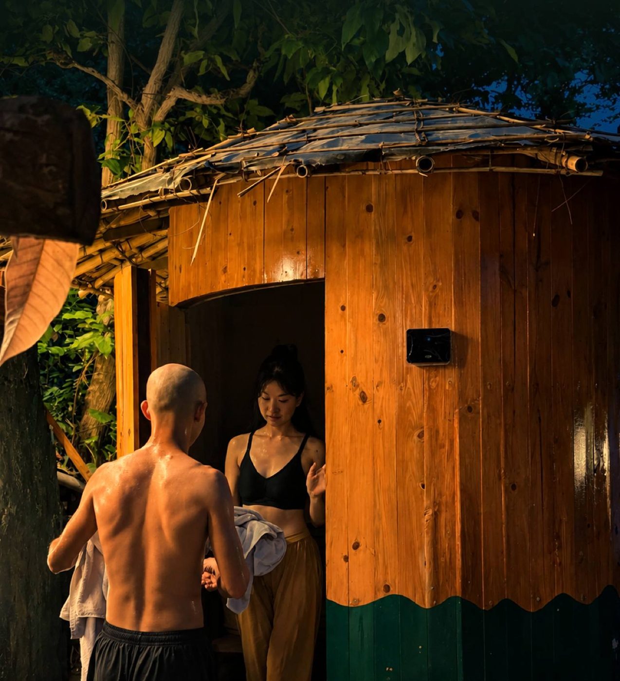 Guests stepping out of the round cedar sauna at Tapas in the forest