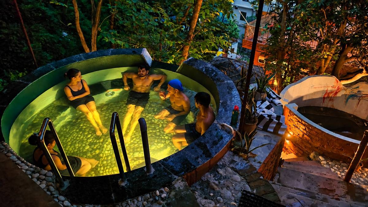 Guests talking in the glowing soaking pool at night