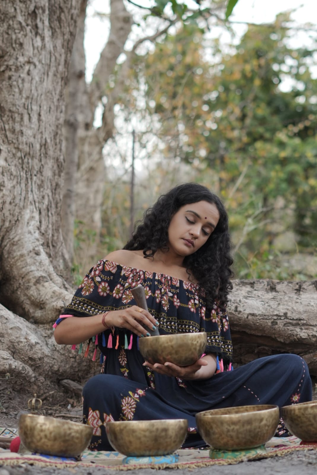Ramana playing Tibetan singing bowls during a sound healing session at Aavya in Tapovan Rishikesh